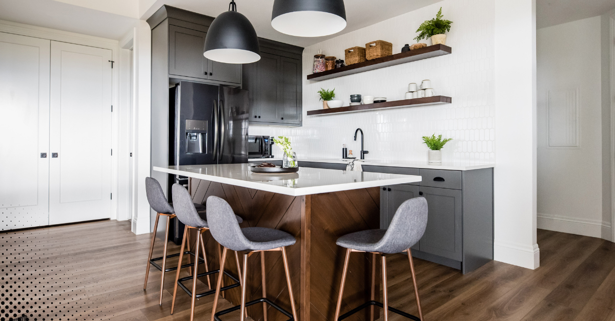 Modern kitchen with a large island, sleek gray cabinetry, open shelving, and contemporary lighting fixtures.