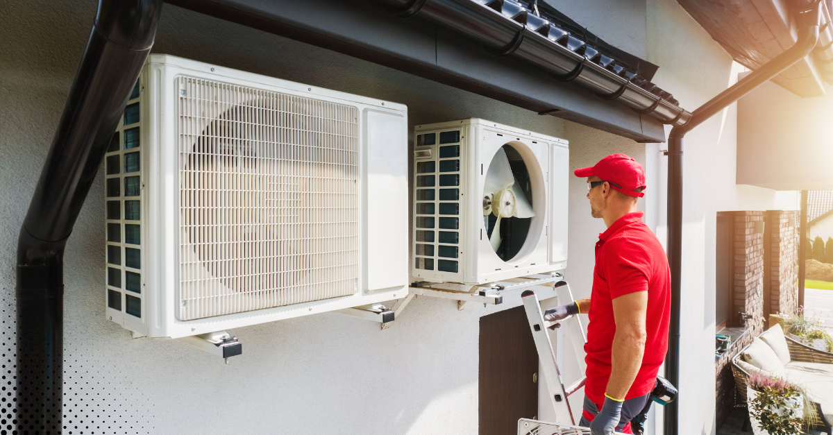 Inspector examining outdoor HVAC units on a home.