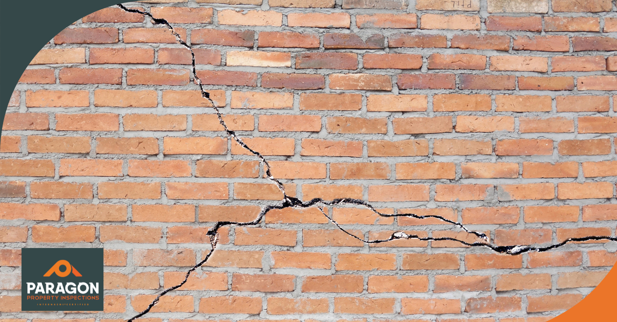 Cracked brick wall showing visible gaps and damage.