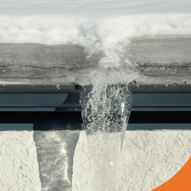 Ice buildup and frozen gutters on a snow-covered roof.
