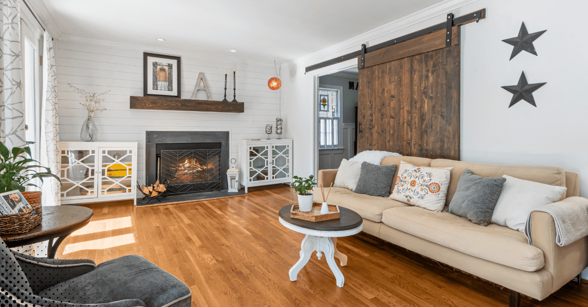 Cozy living room with a fireplace, comfortable couch, and rustic barn door accent.